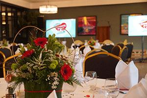 Photo of flowers on the table, with presentation screens in the background.