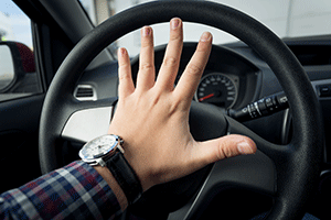 Hand with palm stretched on a steering wheel