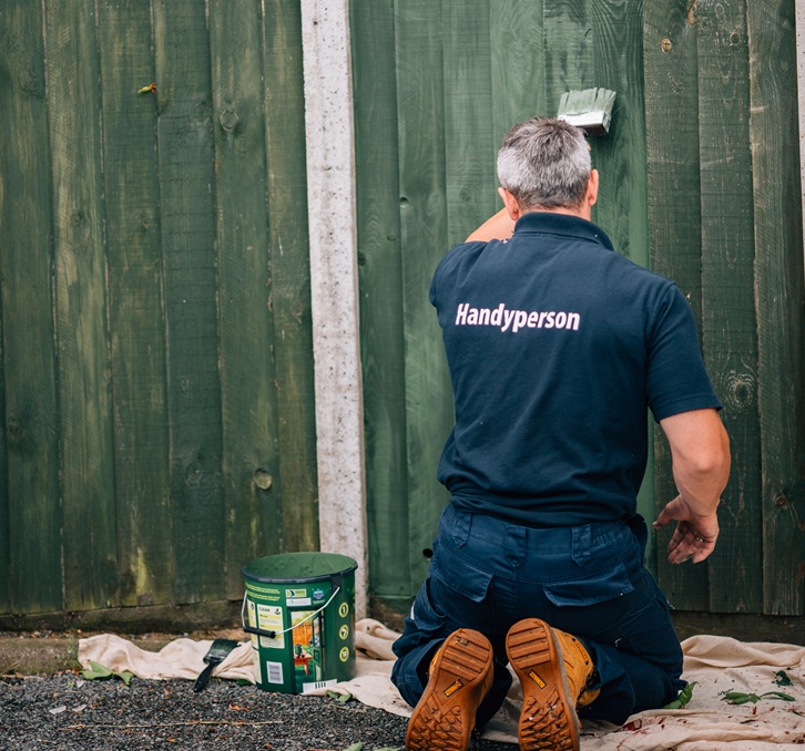 Handyperson painting a fence