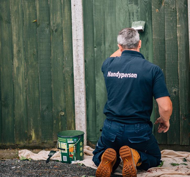 Handyperson painting a fence