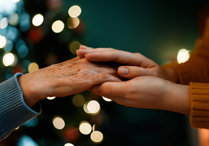 Older hand holding younger hands