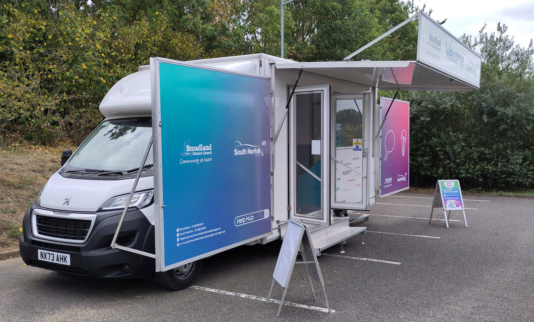 Help Hub van in a car park, with banners up