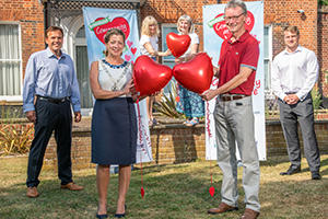 Chaiman of Broadland District Council councillor Karen Vincent and leader of the council shaun Vincent and John Warren from Price Bailey stand with heart shaped balloons and community at heart banners