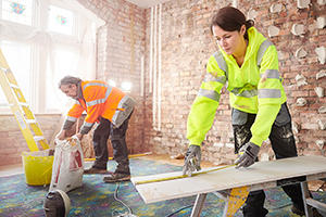 A young female builder and older male builder doing work on site