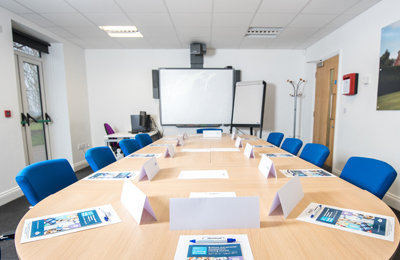 A training or meeting room at Carrowbreck House, showing a large table with chairs and a projector screen