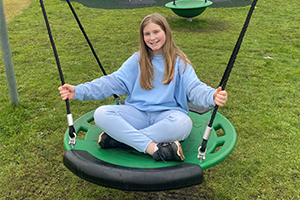 Ten year old girl called Charmaine Blythe on a swing at park view play area by horsford village hall