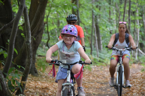 Young girl and family cycling on the Sweet Chestnut Family Cycle trails