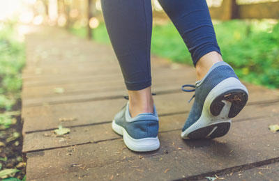 close up of a womens feet as she walks down a path outside