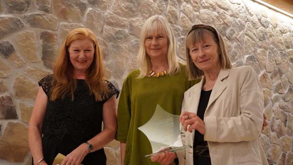 Two ladies receiving a glass star trophy