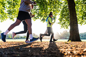 Four people running in a park