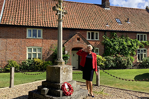 Councillor Jo Copplestone saluting at a war memorial