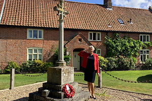 Councillor Jo Copplestone saluting at a war memorial