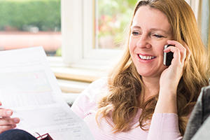 Women on a mobile phone looking at a piece of paper