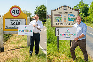 Shaun Vincent holding up a confidence campaign sign next to an Acle sign and John Fuller holding up a confidence campaign sign next to a Harleston sign