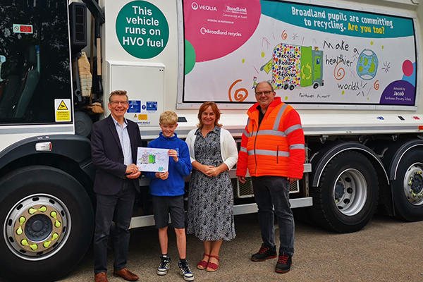 Cllr Jan Davis with Rackheath primary school student Jacob and his teacher and Veolia Contract Manager Duncan McBurney infront of the bin lorry banner design