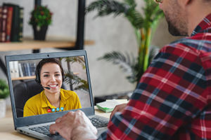Man with a laptop in front of him on a virtual call