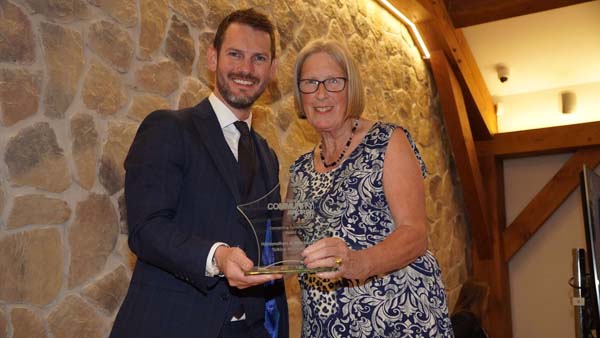 Young man presenting lady with glass star trophy