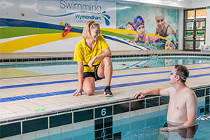 Lifeguard talking to a swimmer in the pool at Wymondham Leisure Centre