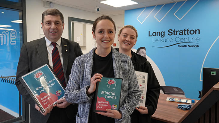 Cllr Graham Minshull with staff at Long Stratton Leisure Centre holding Mindful Towns information
