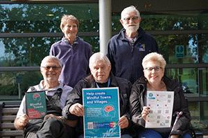 photo of three men and two ladies, holding certificates and smiling at the camera