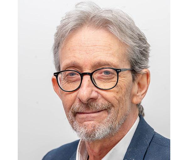 Headshot of man, wearing glasses short hair and a beard. Smiling at the camera