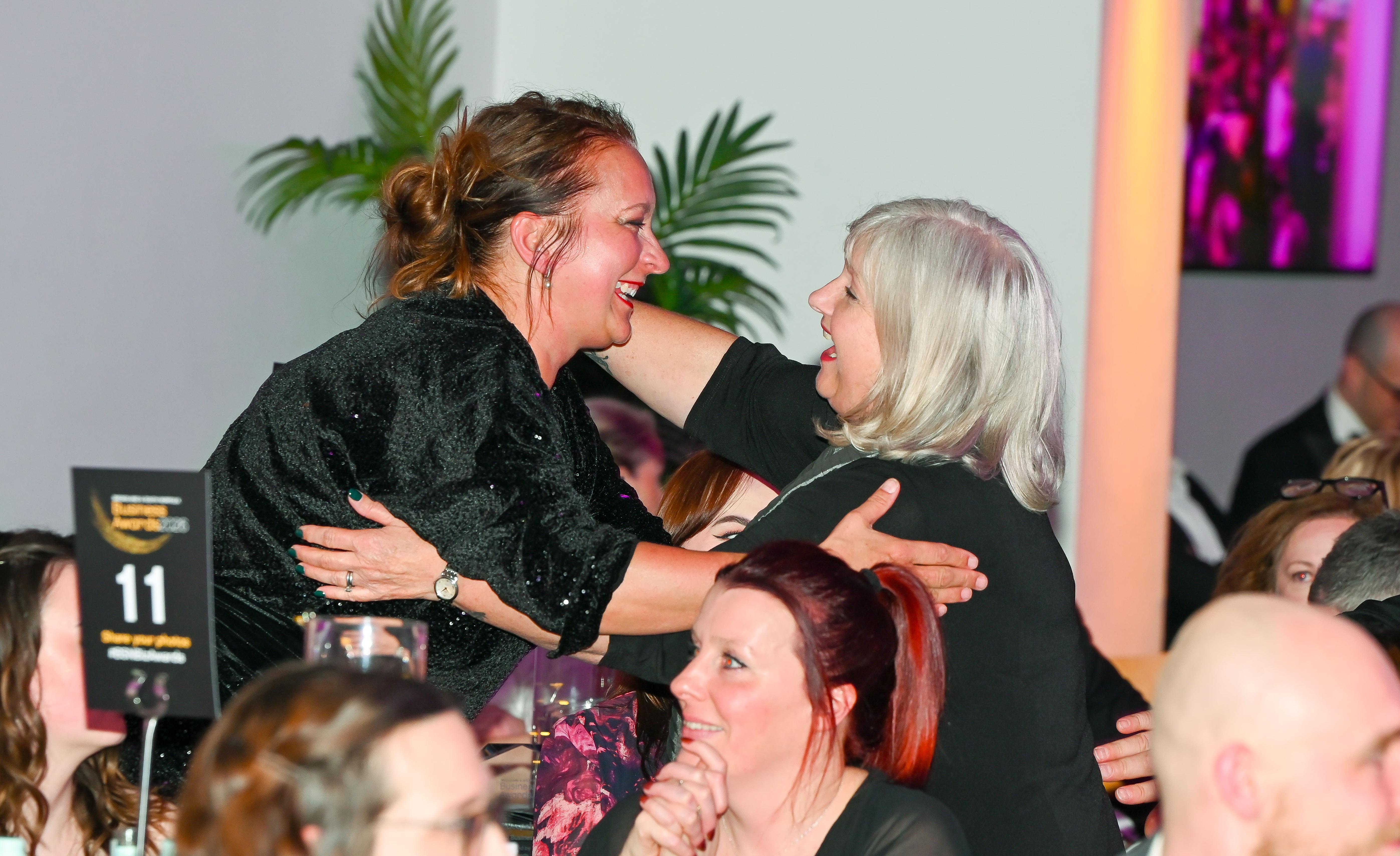 Two female guests hugging to congratulate each other at the 2026 Business Awards