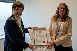 two ladies, holding a certificate