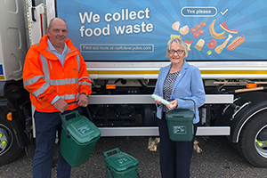 Duncan McBurney, Contract Manager at Veolia with Cllr Judy Leggett, Portfolio Holder for Environmental Excellence with food caddies infront of a food waste truck