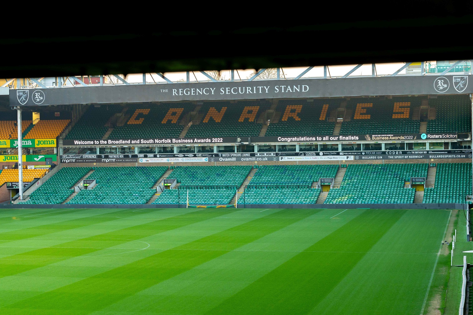 Norwich City Football Club pitch with digital sign welcome to the Business Awards 2022