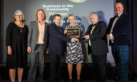 Clinks care farm accepting their trophy and certificate for the business in the community award