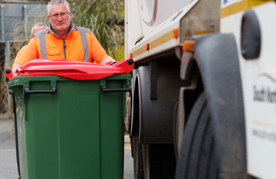 Bin man collecting a commercial waste bin