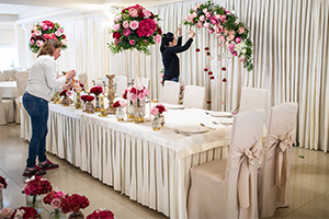 Two women arranging flowers at a venue for a wedding