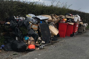 A pile of rubbish flytipped on the side of a road