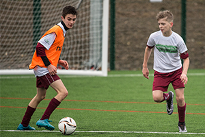 Two teenage boys playing football on a 3g pitch at Long Stratton Leisure Centre
